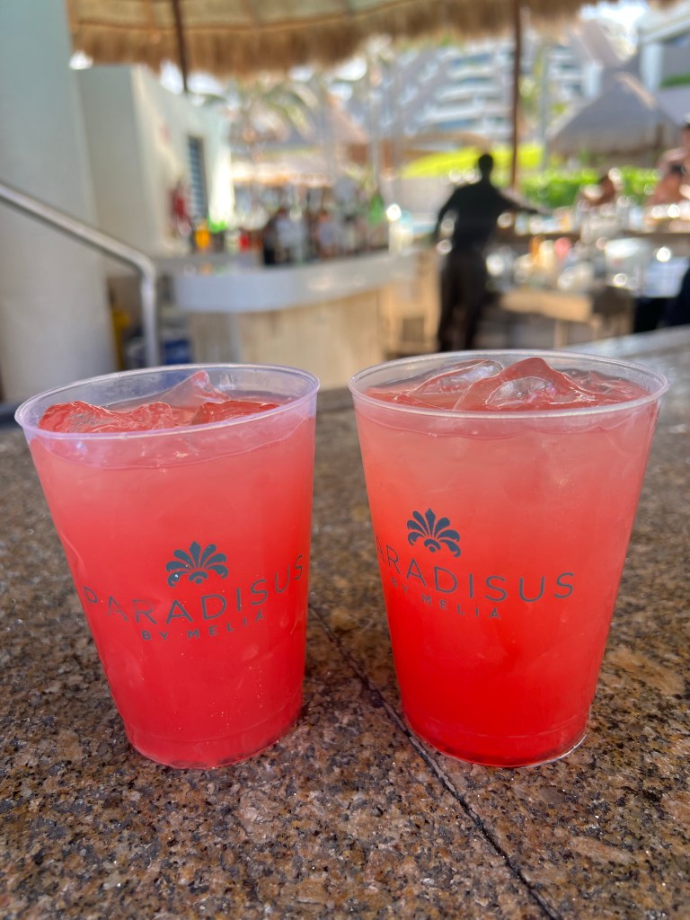 A picture of two rum punches sitting on the pool bar.  