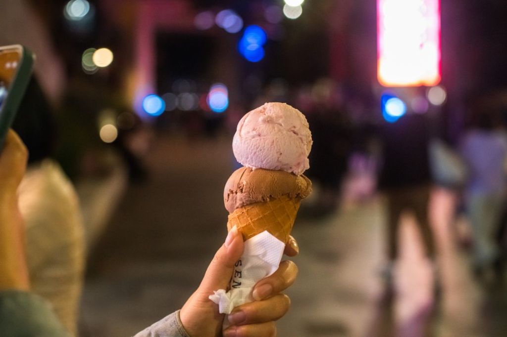 Hand holding an ice-cream cone at night